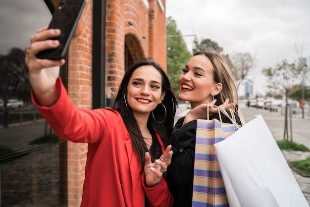 携帯電話でselfieを取る2人の若い友人