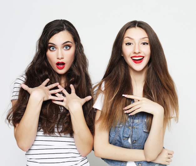 Two young girl friends having fun Both making surprised faces