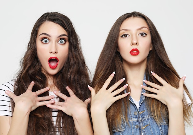 Two young girl friends having fun Both making surprised faces