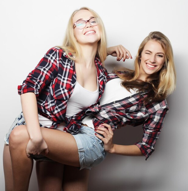 Two young girl friends standing together and having fun