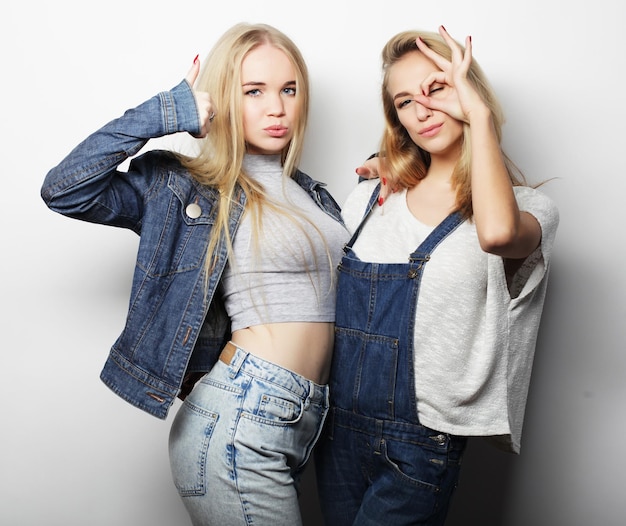 Two young girl friends standing together and having fun