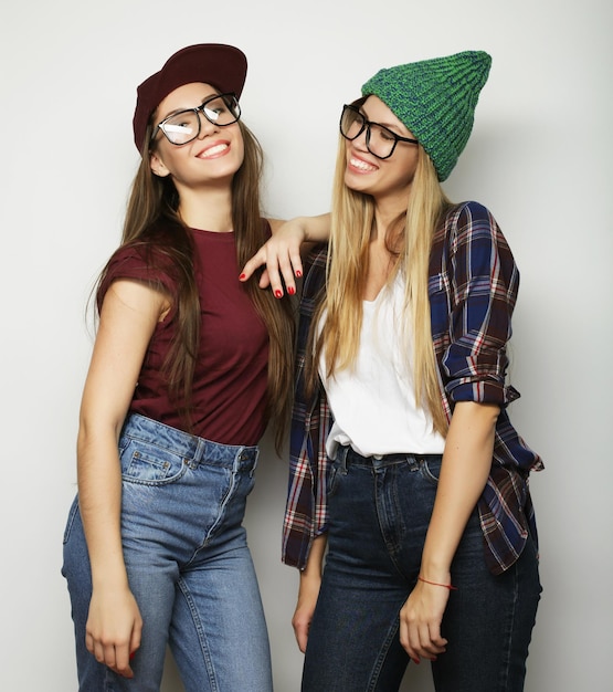 Two young girl friends standing together and having fun