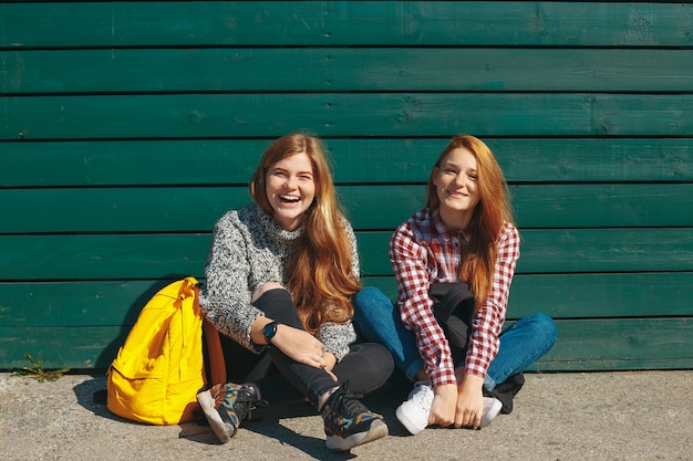 Two young girl friends standing together and having fun