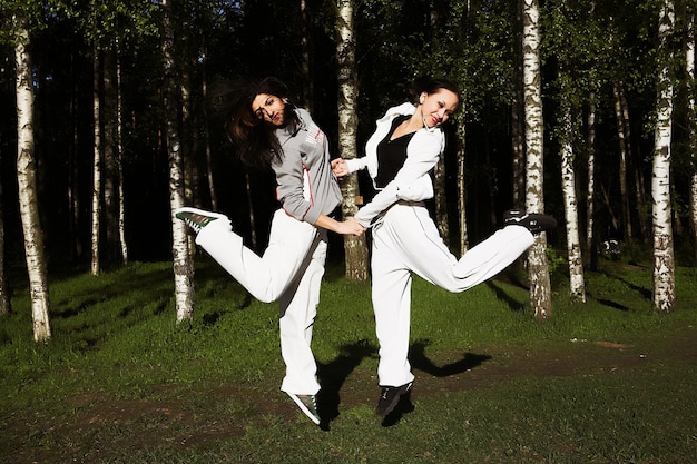 Two young girl jump in park