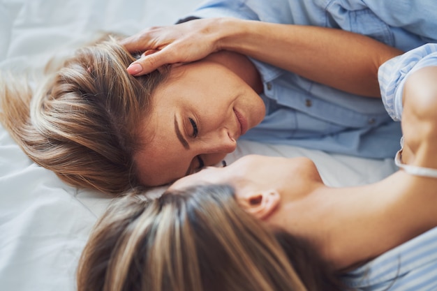 Photo two young girlfriends on the bed. high quality photo