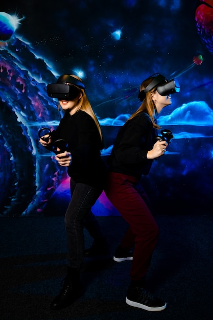 Фото Две молодые подруги сестры с виртуальными очками веселятся вместе и играют в видеоигры.