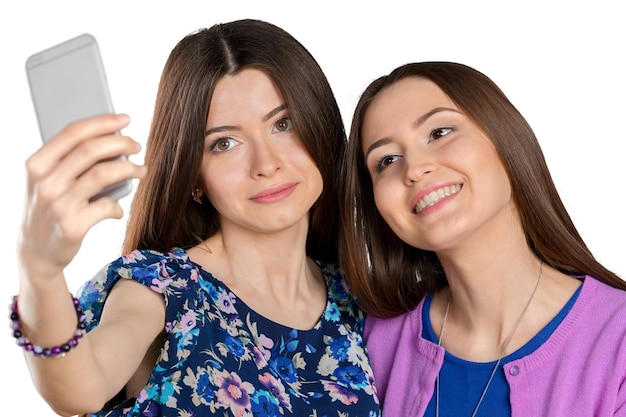 Two young girls using smart phonexA