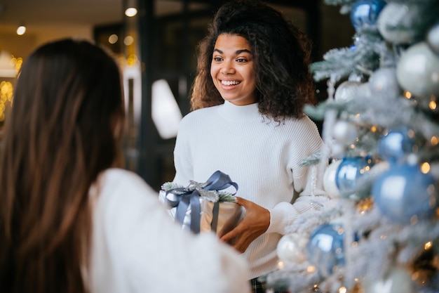 Two young and happy best friends a roommates exchange gifts