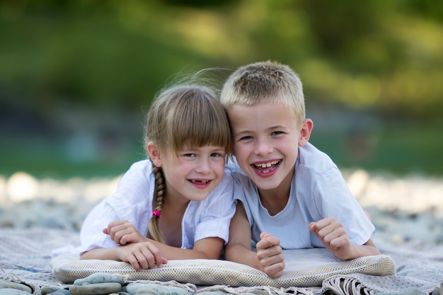 写真 子供、男の子と女の子、兄と妹の小石のビーチに抱きしめる笑みを浮かべて2つの若い幸せなかわいいブロンド