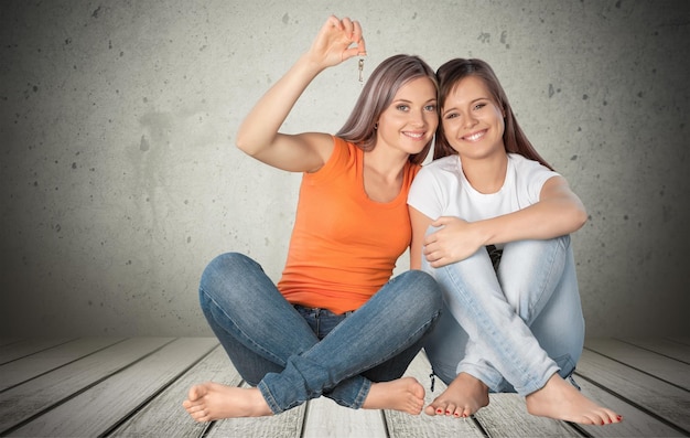 Two young happy women holding key