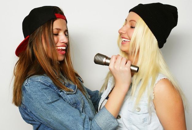 Foto due giovani ragazze hipster che cantano