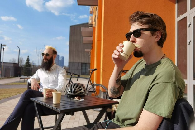 Two young hipster guy sitting in a cafe chatting and drinking coffee