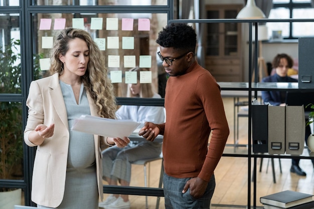 Two young intercultural economists discussing financial papers