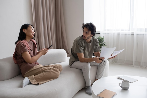 Two young intercultural employees having discussion in home office