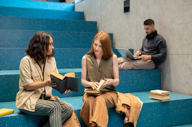 Two young intercultural females discussing books