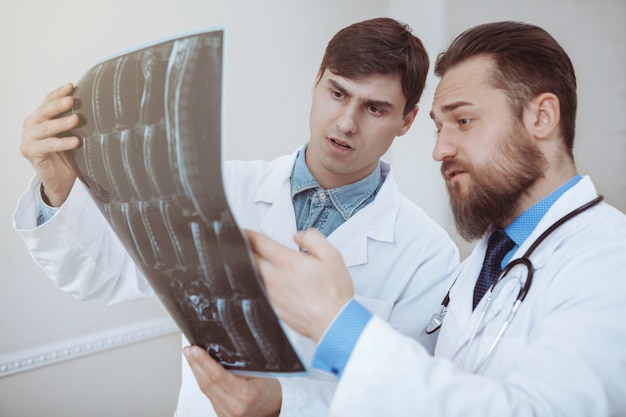 Two young male doctors discussing x-ray scan