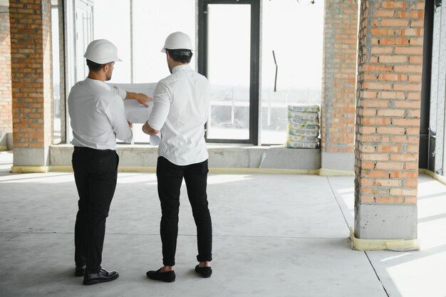 Two young man architect on a building construction site