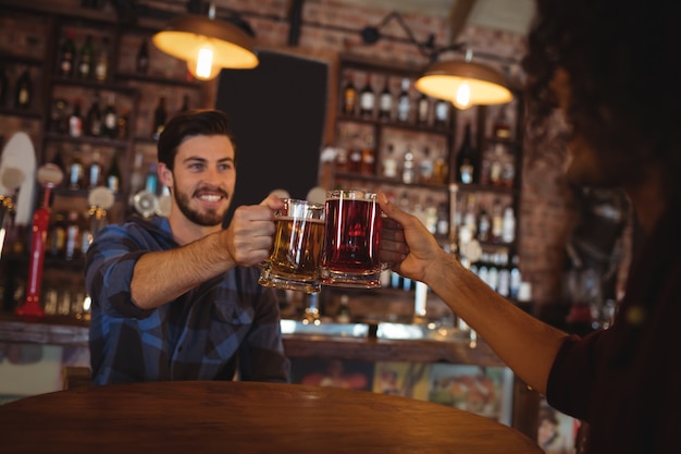 Two young men toasting their beer mugs