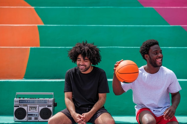 Two young men with afro hair laughing on basketball court