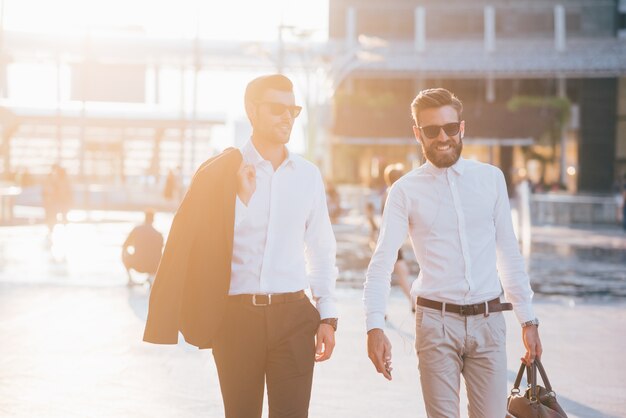 Two young modern businessman posing