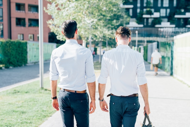 two Young modern businessman posing