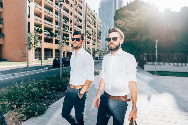 two Young modern businessman posing