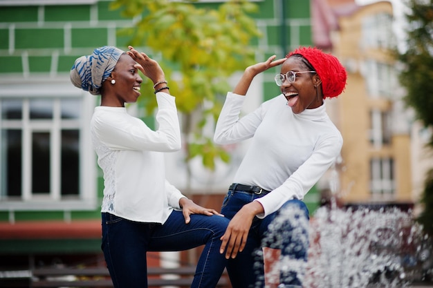 Two young modern fashionable attractive tall and slim african muslim womans in hijab or turban head scarf posed together