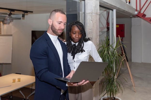 Two young multiethnic entrepreneurs use a digital tablet out of a coworking office