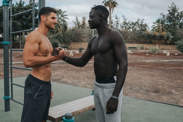 Two young multiracial men exercise outdoors