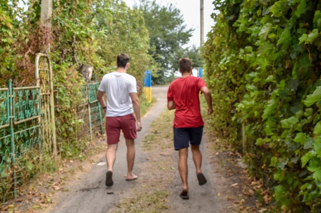 Two young people run towards the open gate view from the back