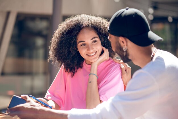 Two young people in street cafe looking at each other