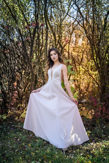 Two young princess wearing nice beige dress in autumn park. Fashion photo.