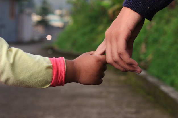 Due giovani sorelle che si tengono per mano camminare all'aperto al pomeriggio