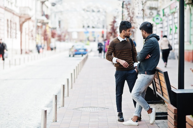 Two young stylish indian man frieds model posing in street.