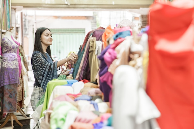 Two young woman shopping at fabric store