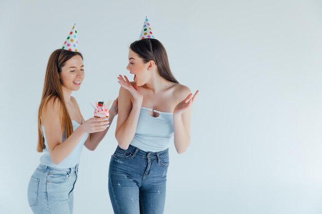 誕生日を祝う誕生日の帽子をかぶった2人の若い女性