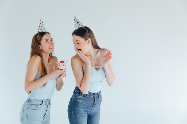 誕生日を祝う誕生日の帽子をかぶった2人の若い女性