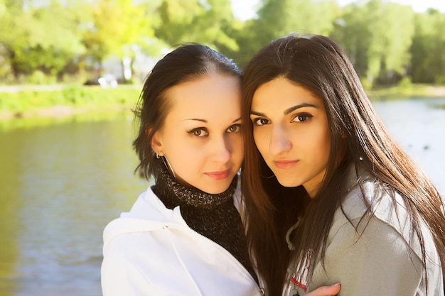 Two young women by the lake having fun