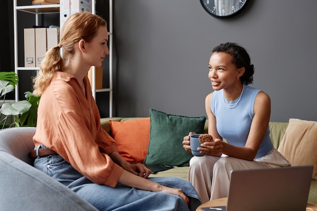 Two young women chatting at coffee break