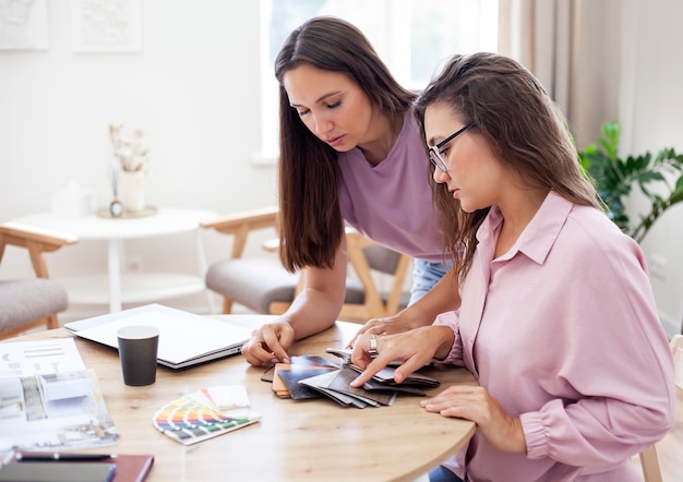 two young women choose a product from a catalog in the office Business concept