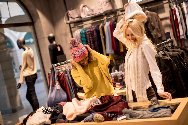 Photo two young women choosing winter clothes