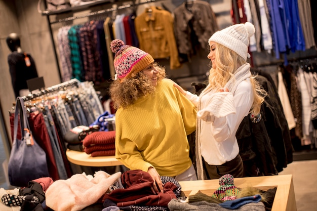 Two young women choosing winter clothes