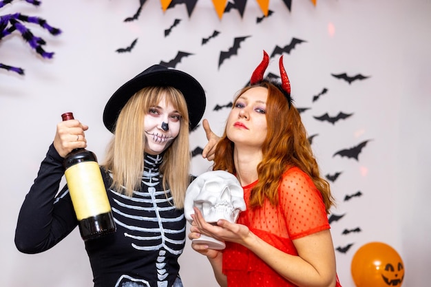 Two young women in costumes at home Halloween party