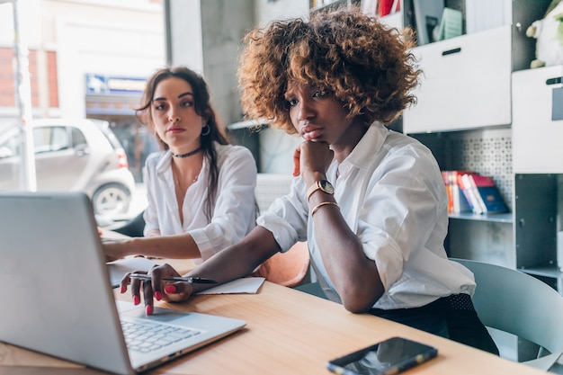 Two young women of creative team working indoor