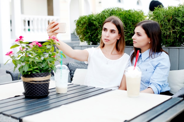 朝のコーヒーを飲みながらselfieを作る2人の若い女性