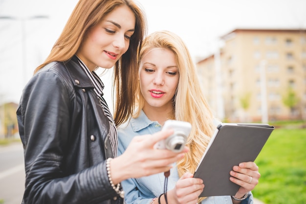 two young women friends using devices