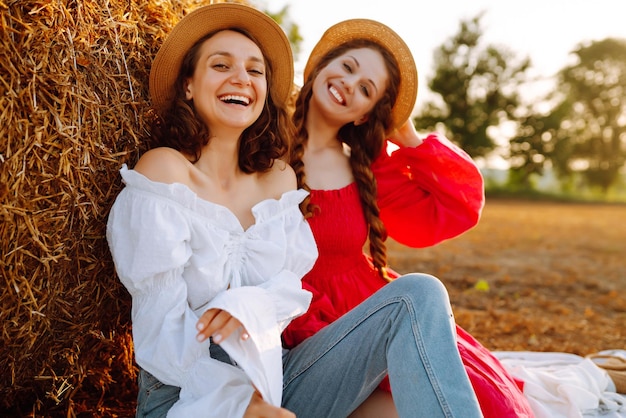 Two young women having fun near haystack Fashion concept Summer concept