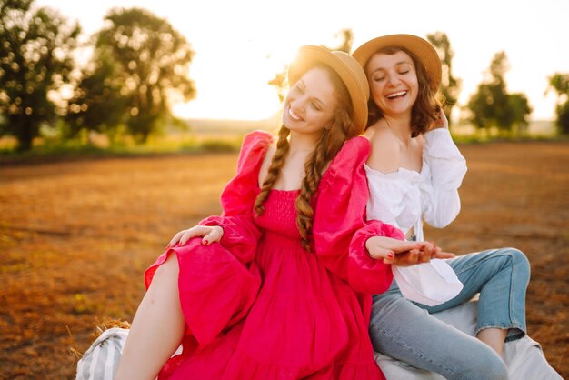 Two young women having fun near haystack Fashion concept Summer concept