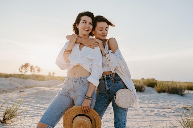 Two young women having fun on the sunset beach