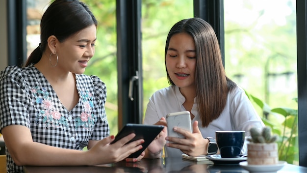 Two young women Looking at a smartphone, shop online.